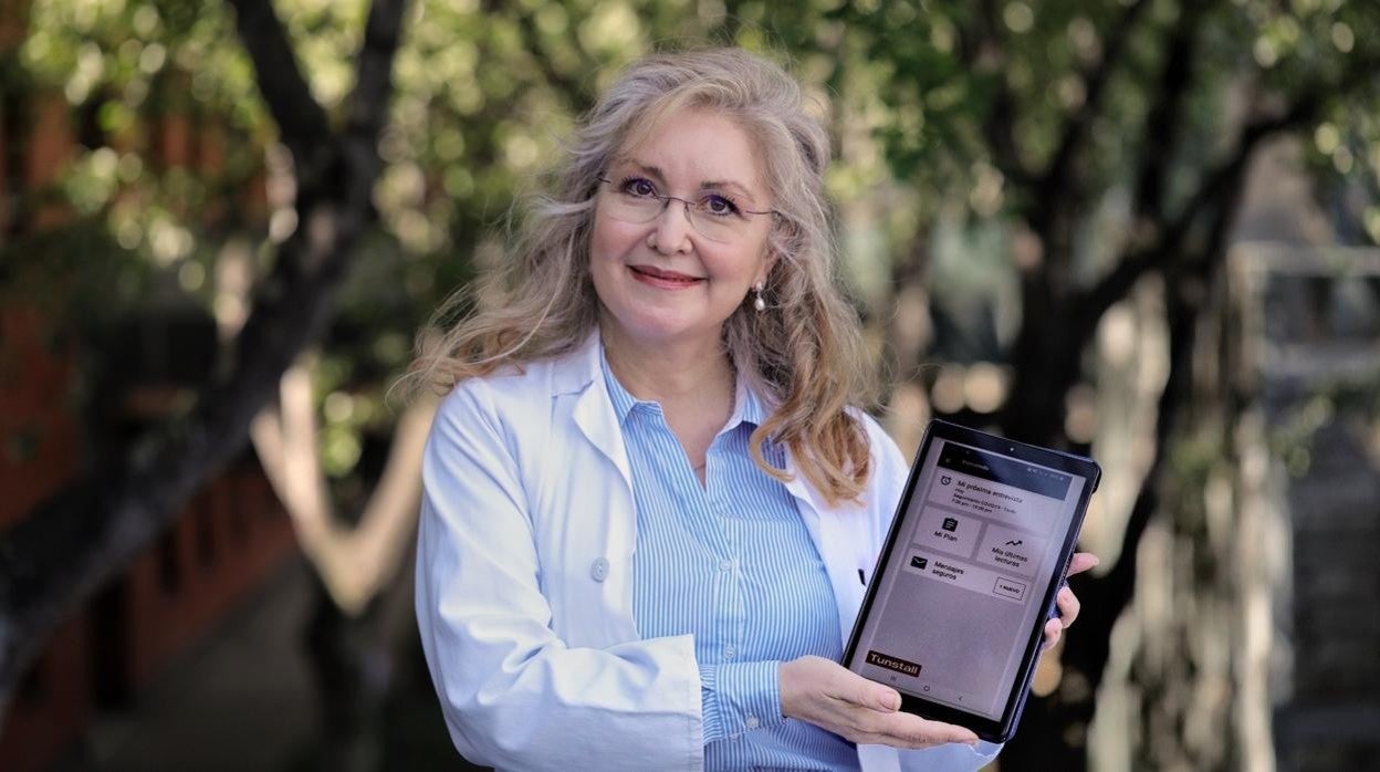 La doctora Rosa Conde muestra la aplicación en un dispositivo movil