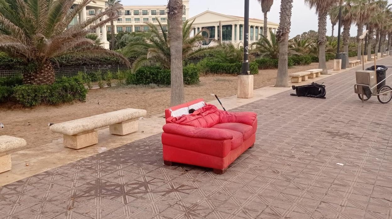 Enseres en el paseo marítimo de la playa en Valencia, tras los botellones de la madrugada de este sábado