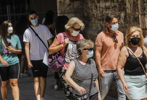 Imagen tomada este miércoles a personas con mascarilla en Valencia