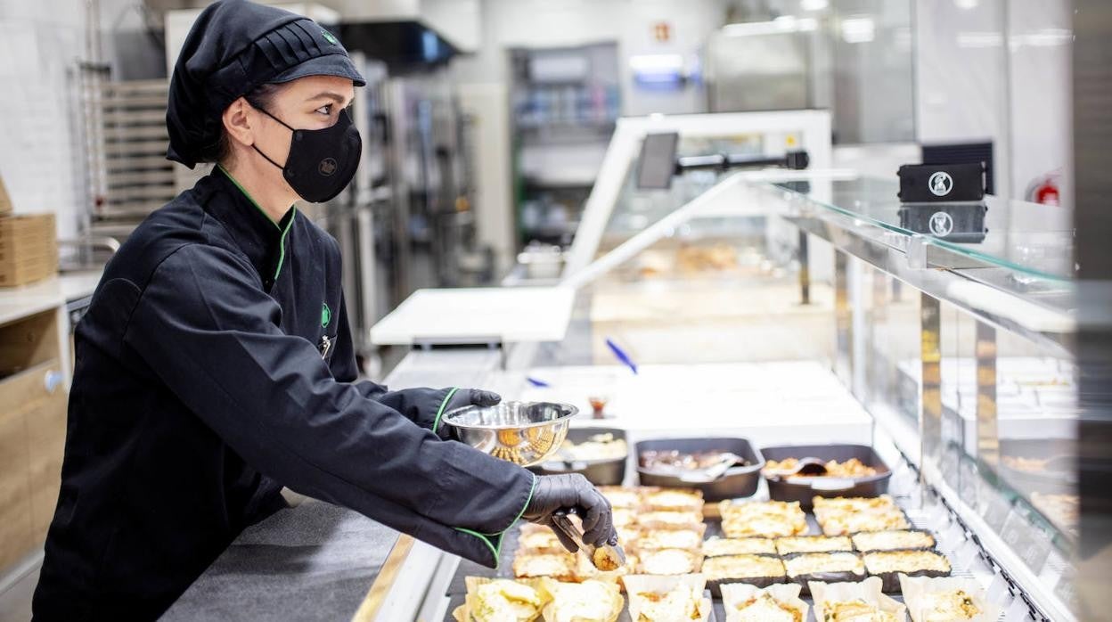 Trabajadora de Mercadona despacha comida para llevar.