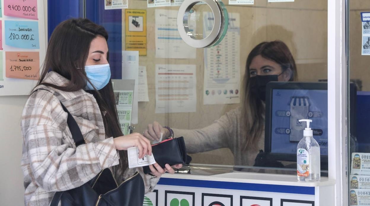 Foto de archivo de una clienta comprando en una Administración de Lotería.