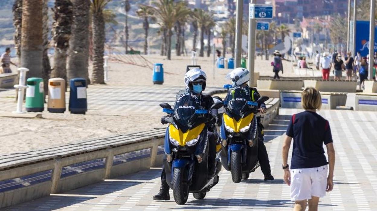 Dos agentes de la Policía Local de Alicante patrullan por la Playa de San Juan