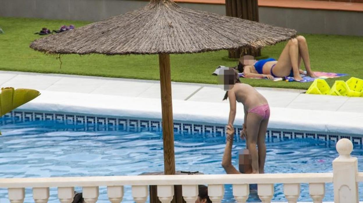 Una niña juega en los hombros de un adulto en una piscina