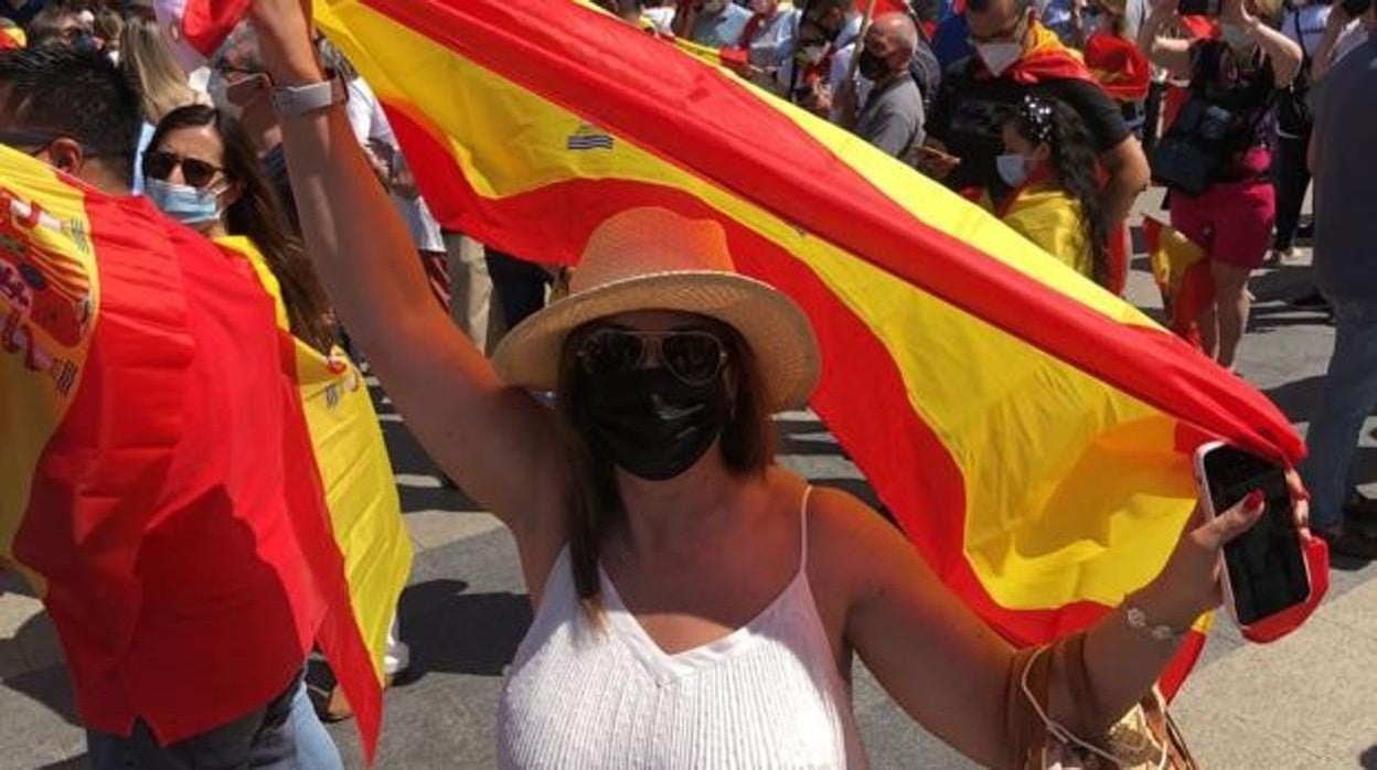 La procuradora de Ciudadanos, Marta Sanz, con la bandera de España en la manifestación de Colón