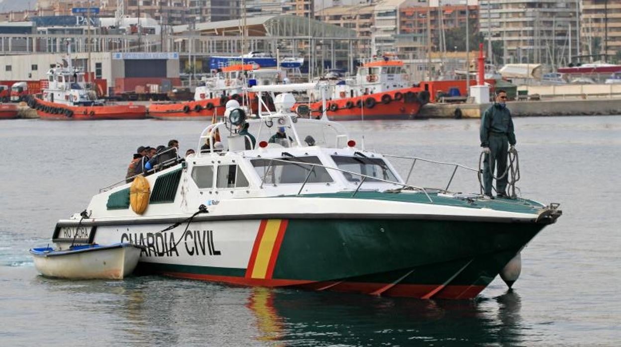 Patrullera de la Guardia Civil entrando en el puerto de Alicante con una patera