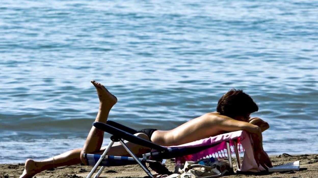 Una mujer toma el sol en el Rincón de la Victoria (Málaga)