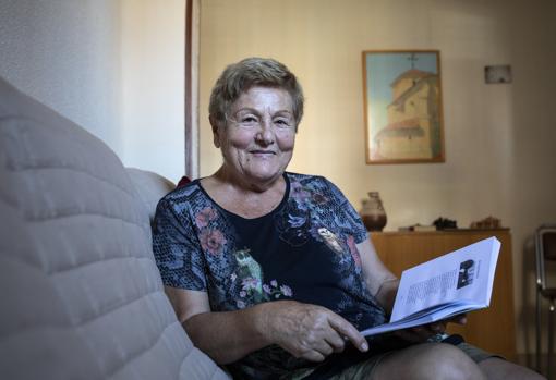 María García, en su salón, posa con uno de sus romances publicados