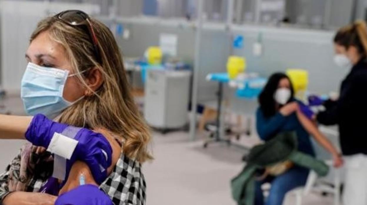 Dos mujeres, recibiendo su dosis de vacuna del Covid-19 en el Hospital Isabel Zendal