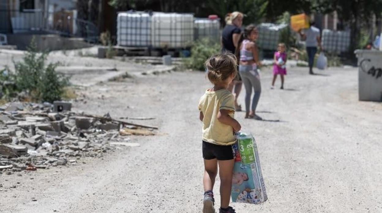 Una niña carga con un paquete de pañales en la zona más depauperada del sector de Perales