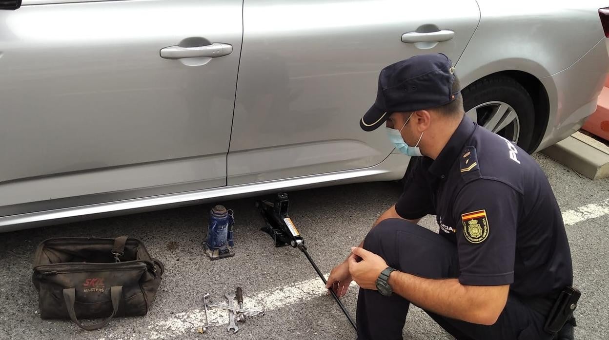 Un agente examina uno de los coches objeto de los robos