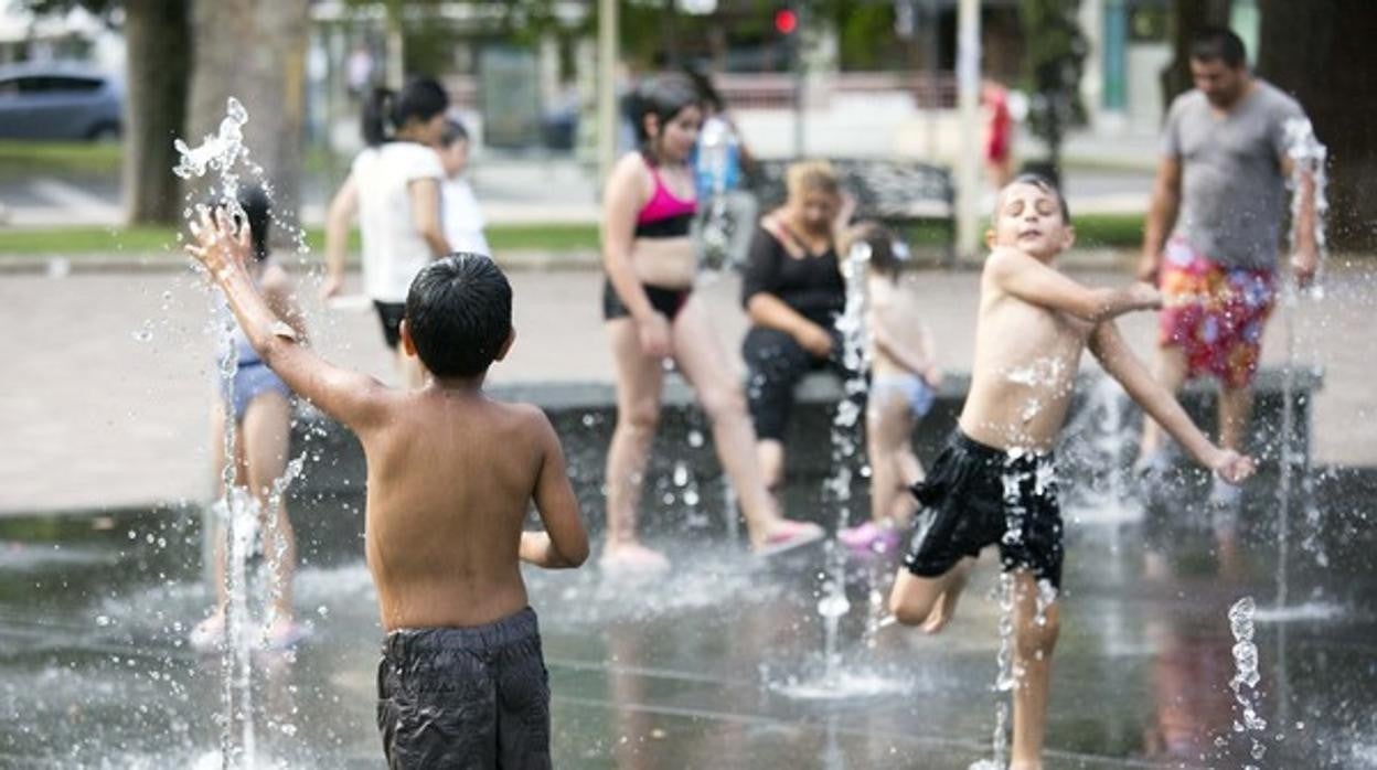 Imagen de unos niños refrescándose en una fuente