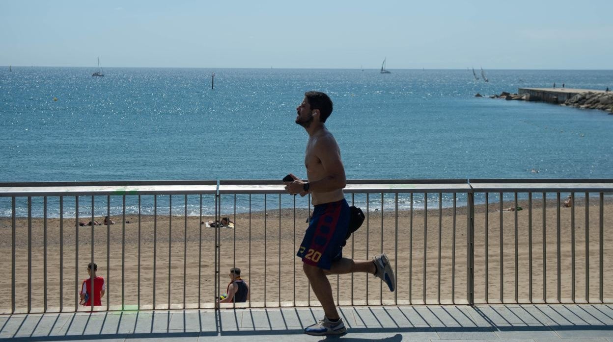 Un corredor en las playas de Barcelona este verano