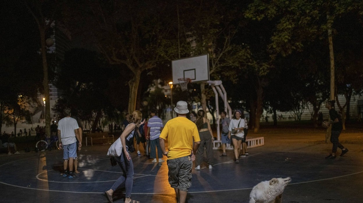 Varias personas en un parque en la primera noche de las fiestas de Sants