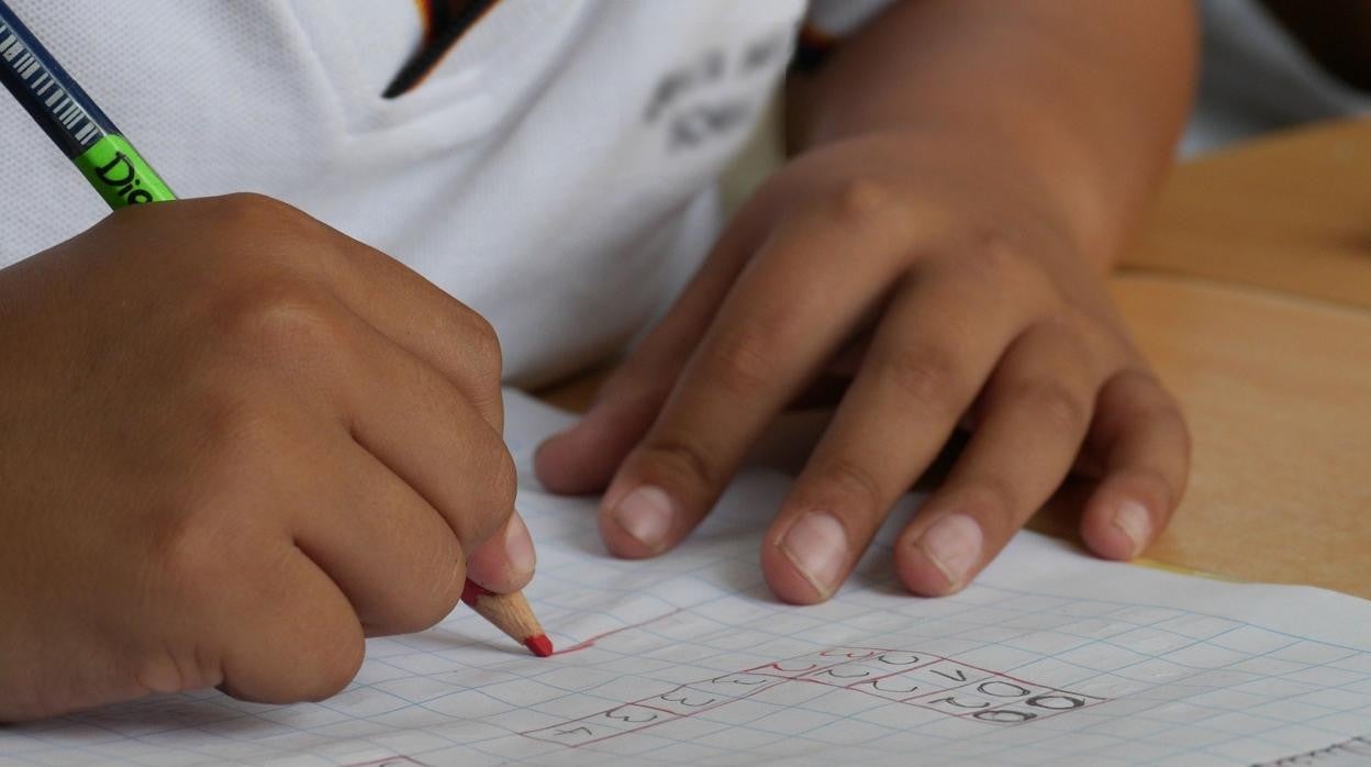 Un niño hace sus deberes en su cuaderno