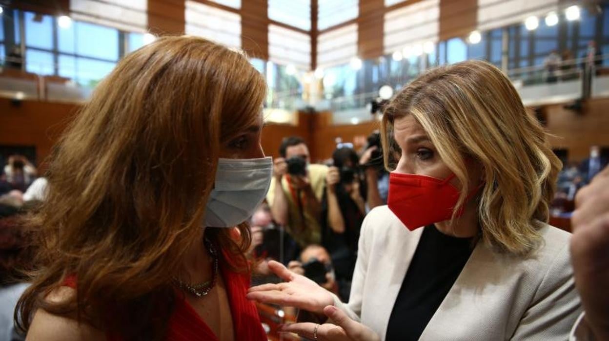 Mónica García (MM), a la izquierda, y Hana Jalloul (PSOE), en la Asamblea madrileña