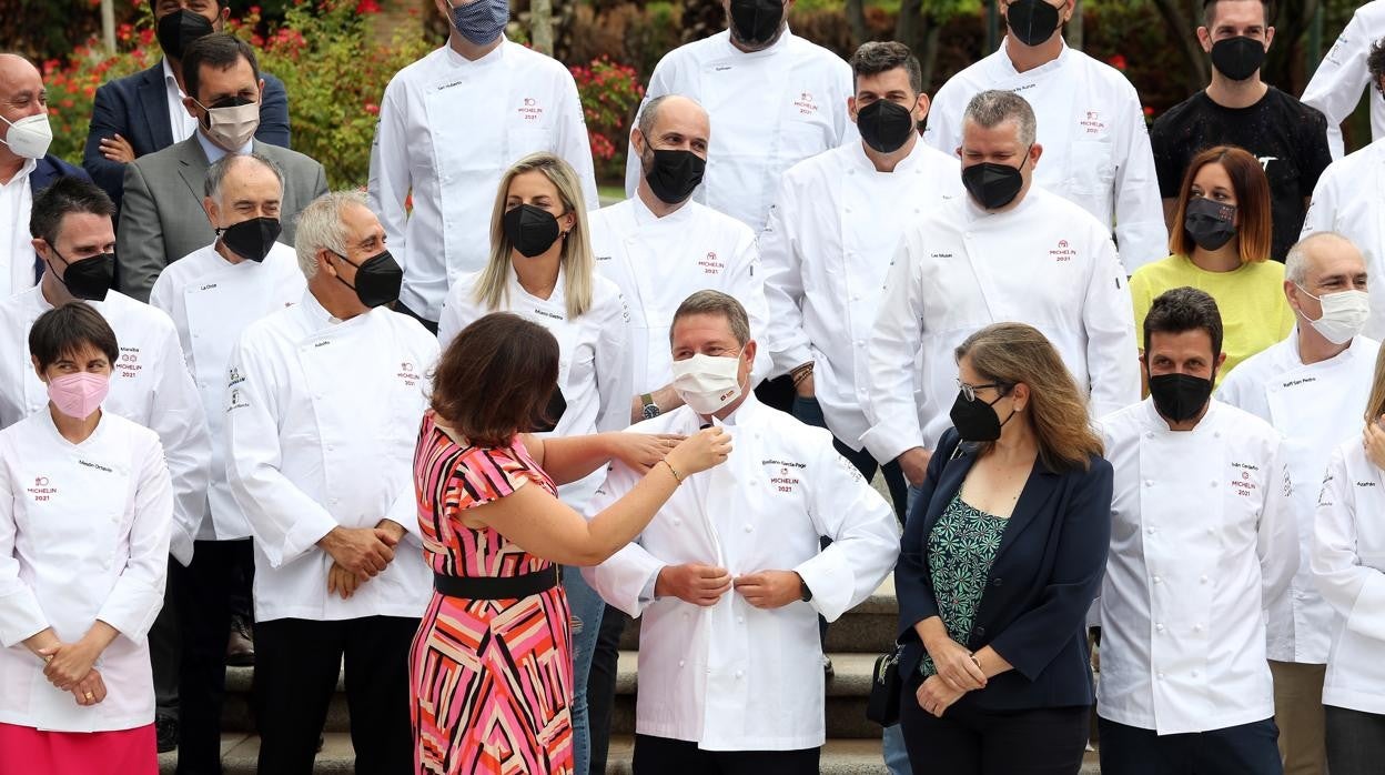 La consejera Patricia Franco ayuda al presidente Gaecía-Page a ponerse una chaquetilla