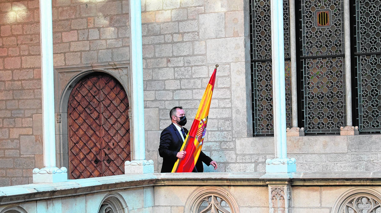 Un ujier retira la bandera española antes de comparecer Aragonès