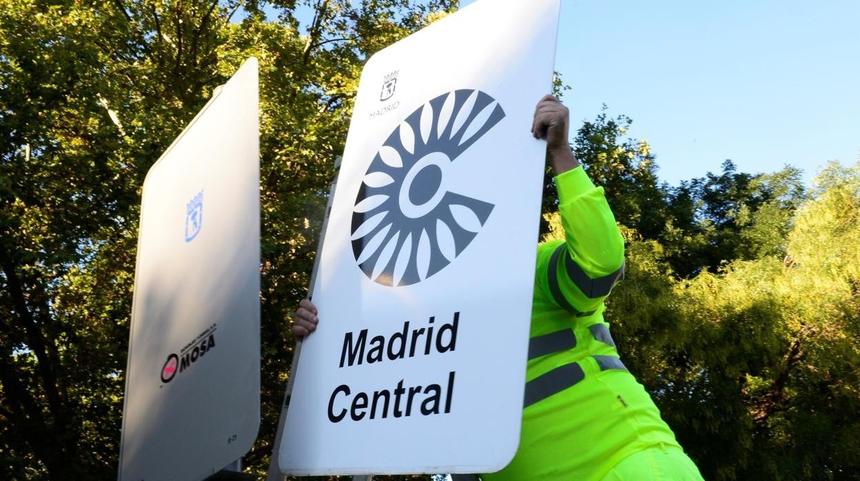 Un operario retira, el pasado domingo, uno de los carteles de Madrid Central