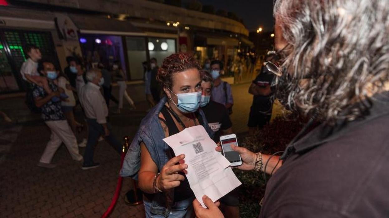 Una mujer enseña el pasaporte Covid en un local de Sanxenxo