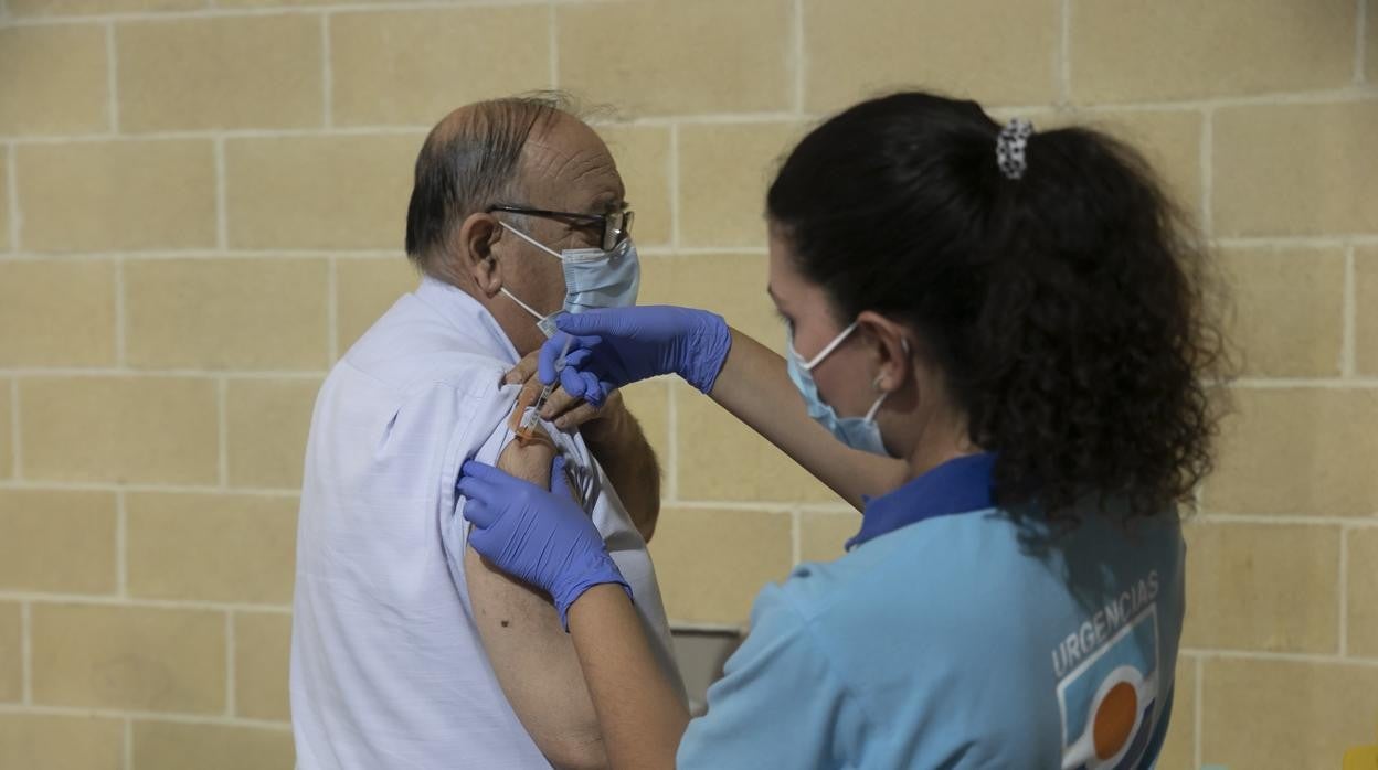 Una sanitaria pone la tercera dosis de la vacuna contra el coronavirus