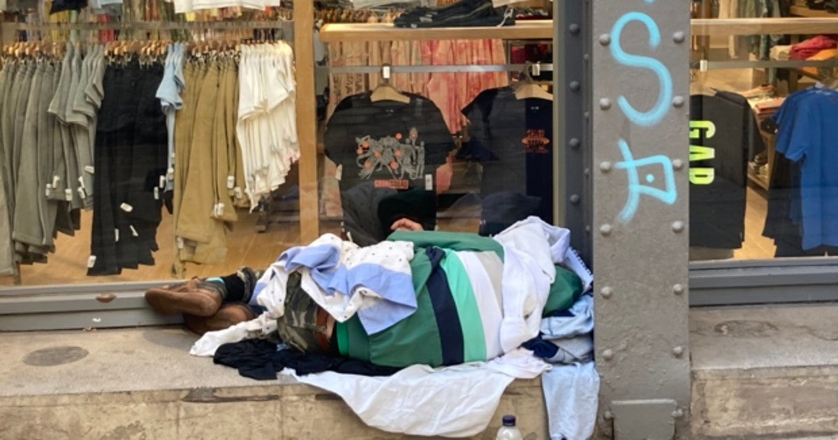 Un hombre sin hogar duerme en una calle de Barcelona