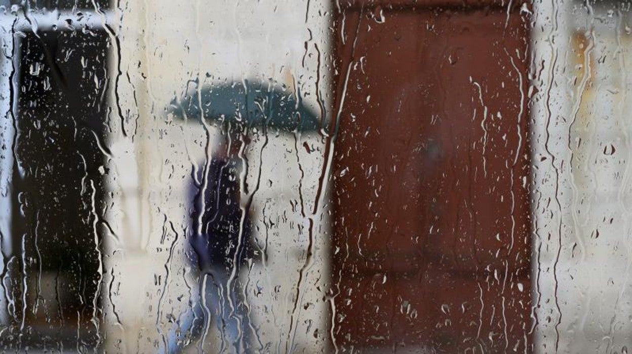 Un viandante pasea bajo la lluvia