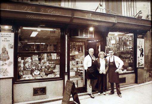 Cuartero con su padres en la puerta de la tienda hace años