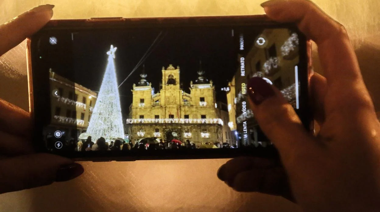 Una mujer toma una foto del encendido de las luces de Navidad de Ferrero Rocher en Astorga (León), ganadora en 2020