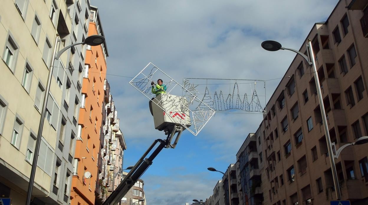 Un operario colocando el alumbrado en una calle de Ponferrada