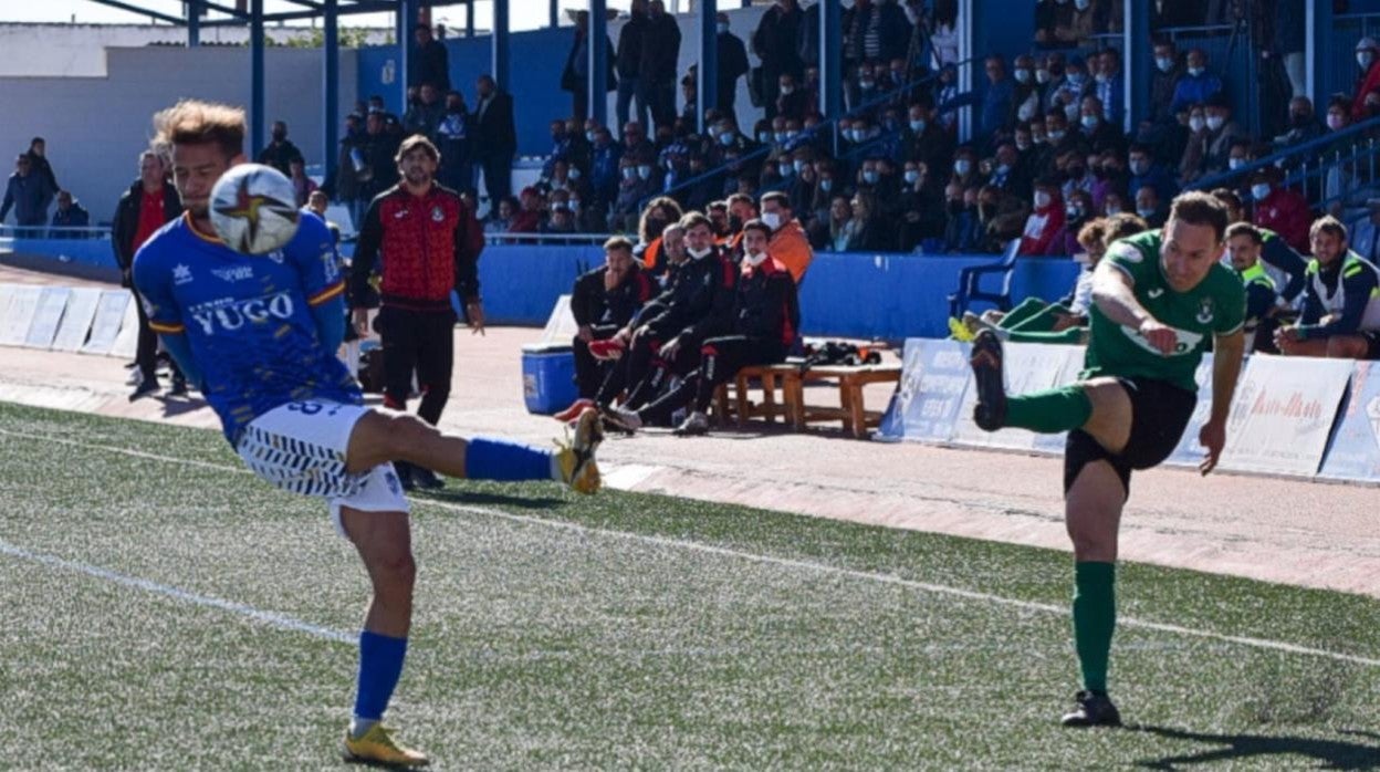 Migue, jugador del Toledo, centra ante un adversario