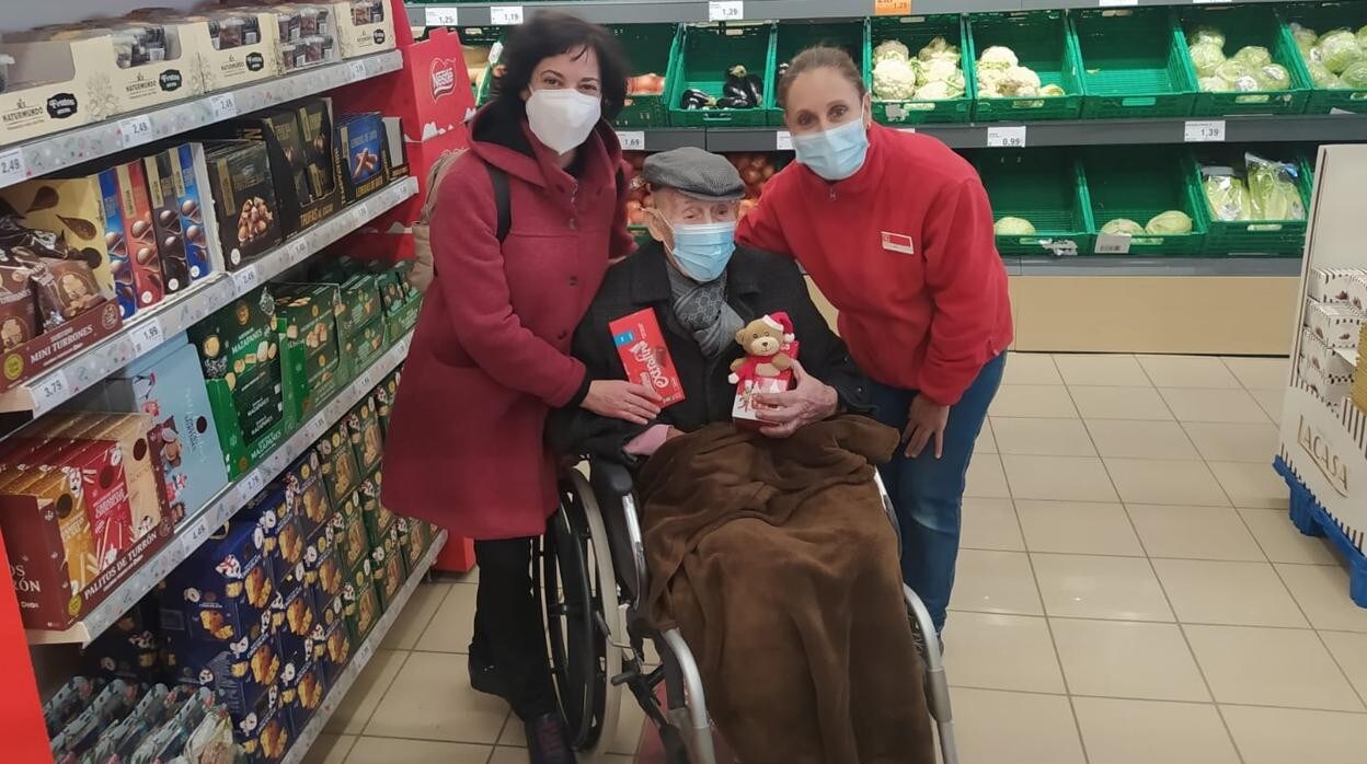 Rafael posa con sus regalos junto a su auxiliar, María, y una de las trabajadoras del supermercado