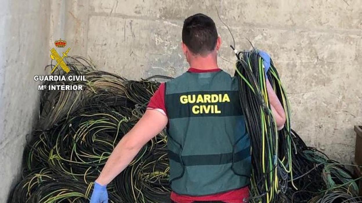 Imagen de una agente de la Guardia Civil junto al cobre sustraído por tres trabajadores de una empresa de Moncofar (Castellón)