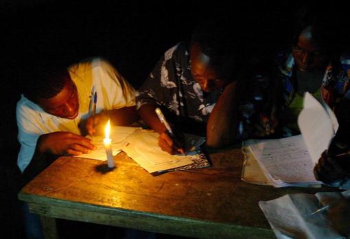 Dos hombres toman notas a la luz de las velas