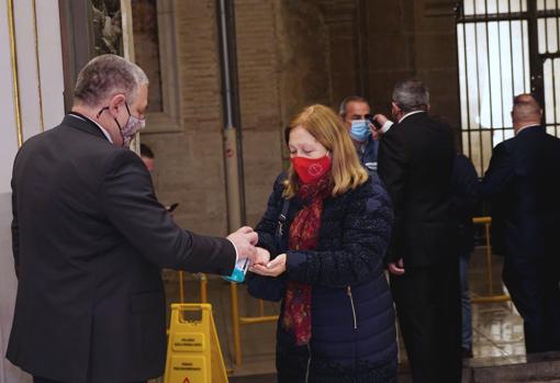 Una devota recibe gel hidroalcóholico antes de acceder a la Basílica de Valencia