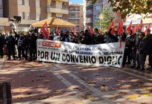 Trabajadores en huelga en Ibi junto a la icónica tartana, símbolo de la industria juguetera, que está englobada en el sector del metal