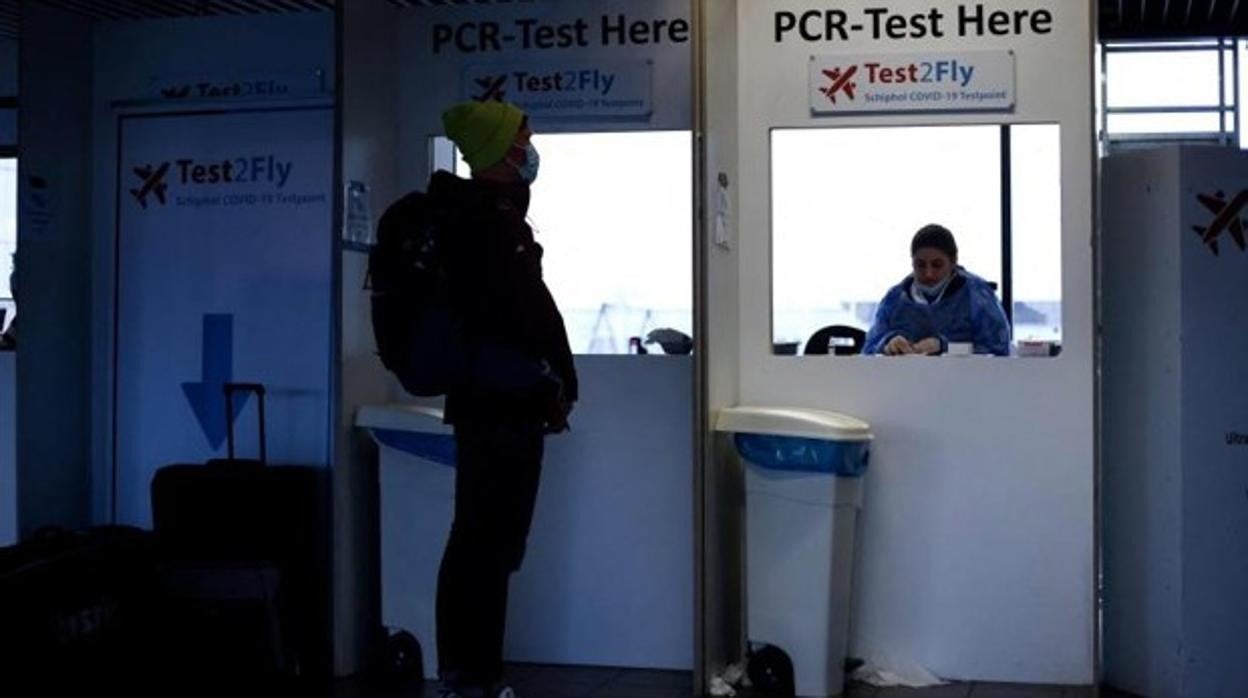 Un viajero procede a hacerse una PCR en un aeropuerto