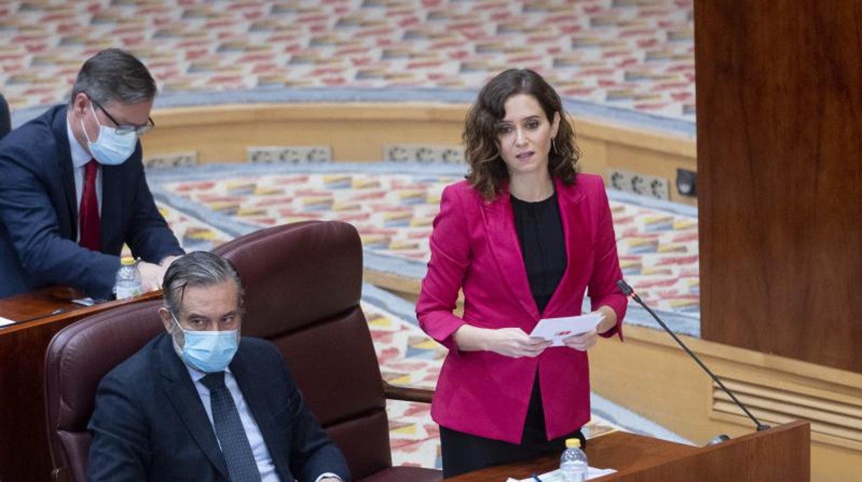 La presidenta de la Comunidad de Madrid, Isabel Díaz Ayuso, junto al consejero de Presidencia, Enrique López, esta mañana en el pleno de la Asamblea regional