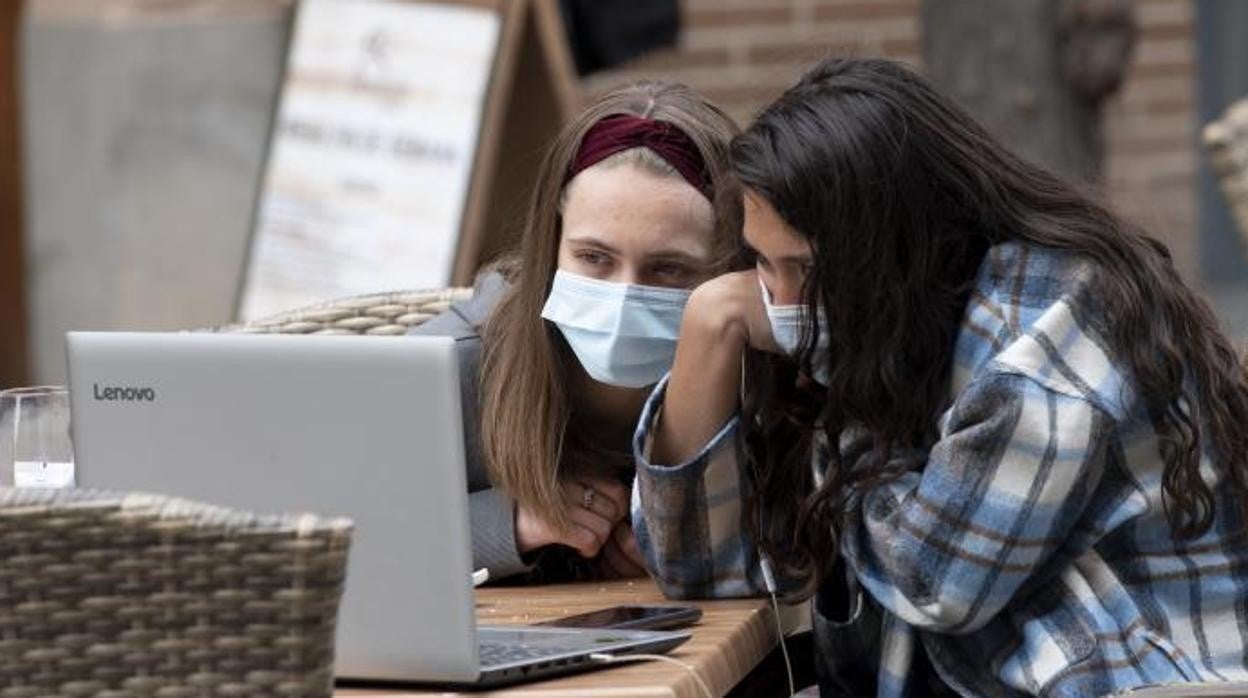 Dos jóvenes consultan el ordenador durante la pandemia