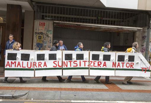 Varias personas sostienen una pancarta con forma de tren en la que se puede leer «Vengo a destrozar a la Madre Tierra» durante una protesta ecologista convocada en Vitoria en 2019
