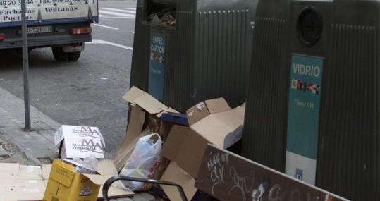 Contenedores de vidrio y cartón en una calle de Madrid