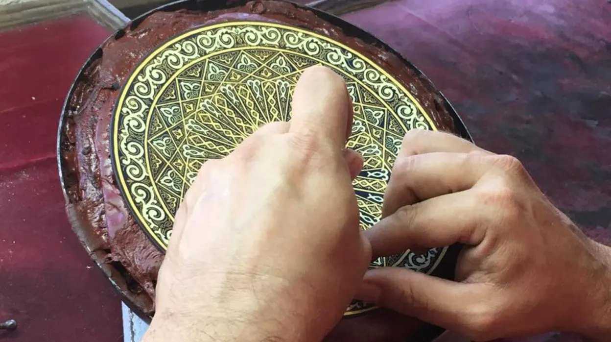 Un damasquinador realiza un plato, una de las piezas tradicionales que se hacen con este arte