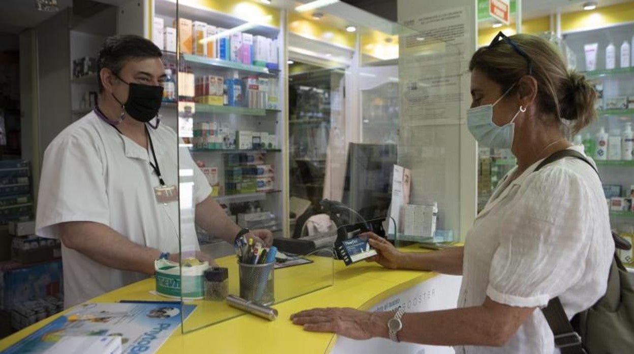 Una ciudadana compra un test de antígenos en una farmacia madrileña