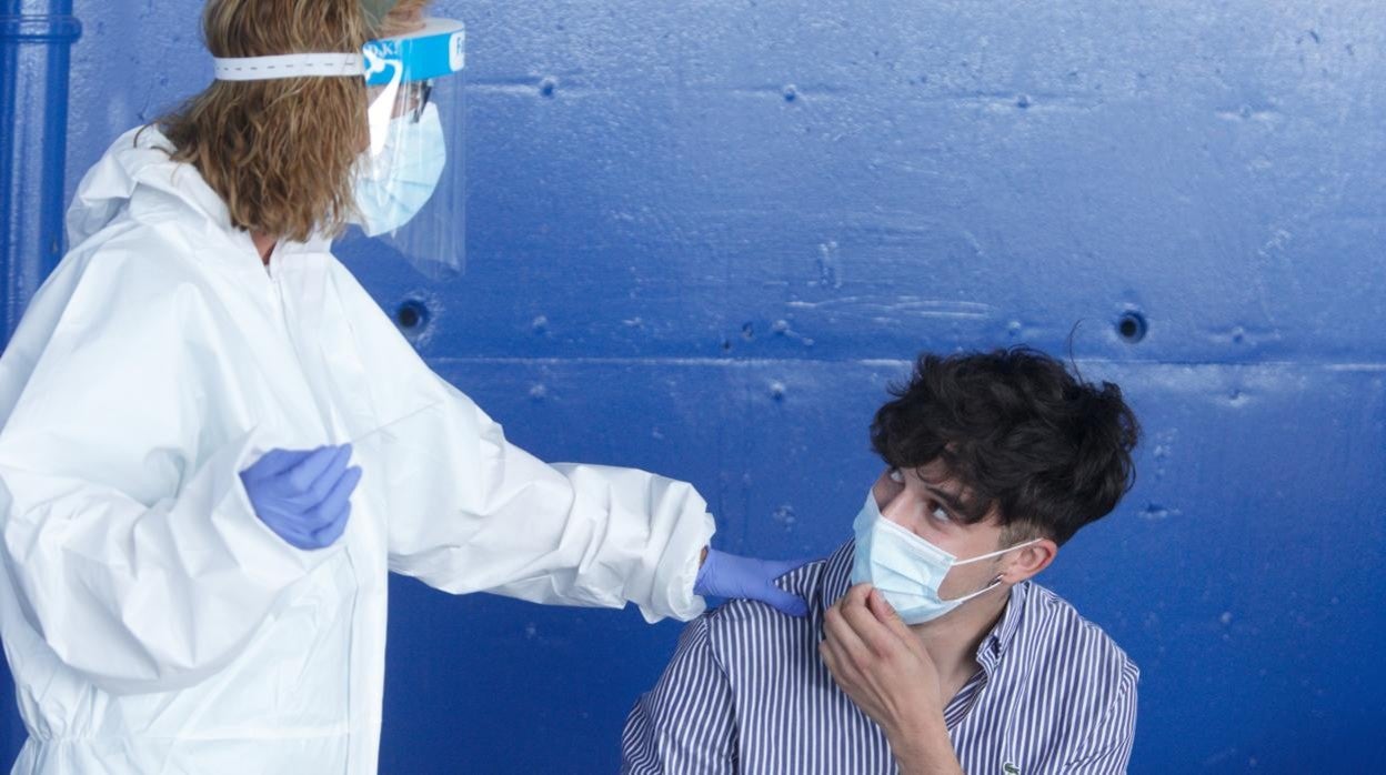 Un profesional sanitario procede a hacer un test de antígenos a un joven