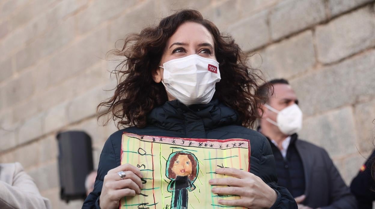 Isabel Díaz Ayuso sostiene un dibujo durante una visita a San Martín de Valdeiglesias