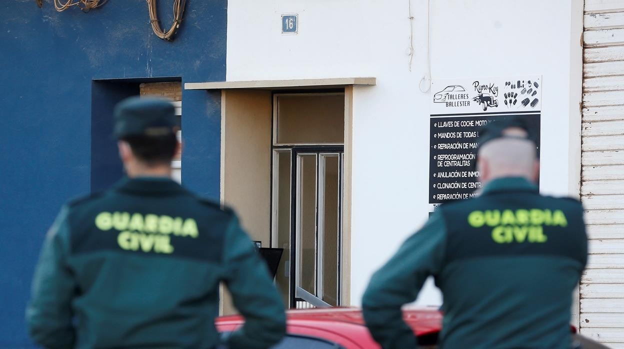 Dos agentes de la Guardia Civil custodian la entrada del edificio donde un hombre fue detenido en Meliana tras apuñalar mortalmente a su padre