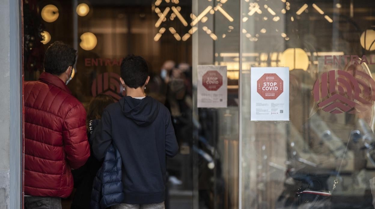 Imagen de un local de hostelería en Valencia con el cartel que señaliza la exigencia del pasaporte covid