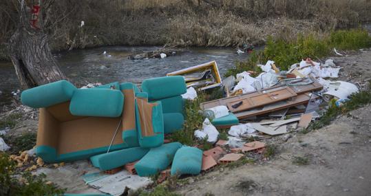 La basura y los escombros cercan el poblado y el río Guadarrama