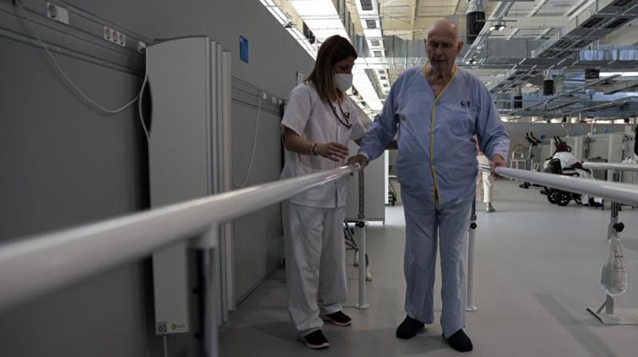 Carlos, uno de los pacientes de la Unidad de Rehabilitación Integral del Zendal, realiza sus ejercicios junto a la fisio Sheila