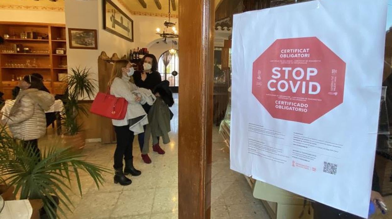 Cartel sobre el pasaporte Covid a la entrada de un restaurante en Alicante