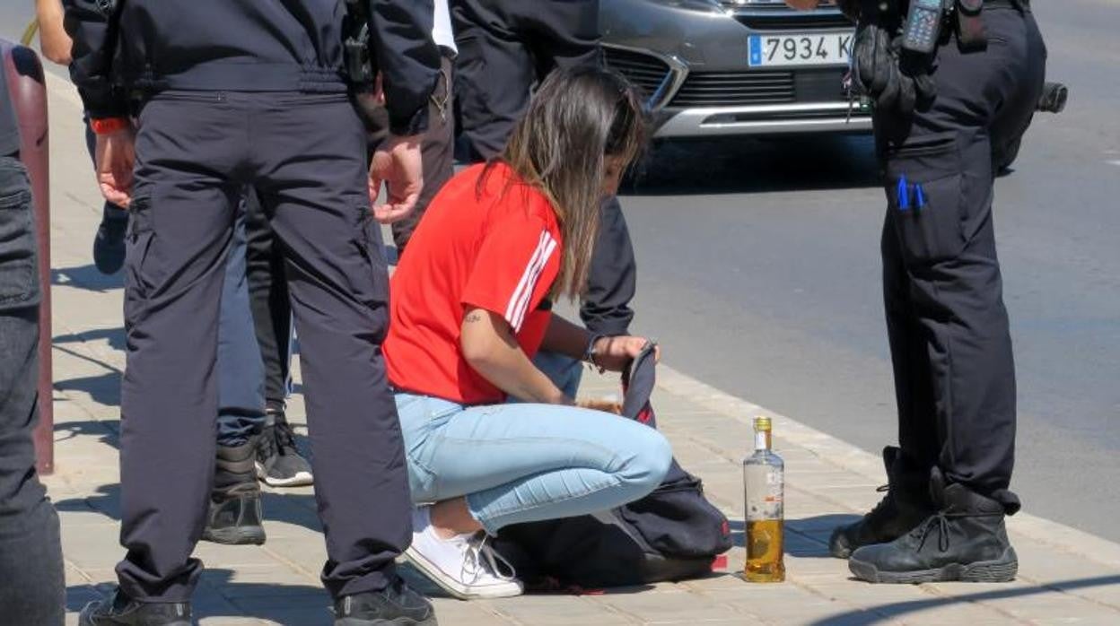 Imagen de archivo de una joven con una botella de alcohol